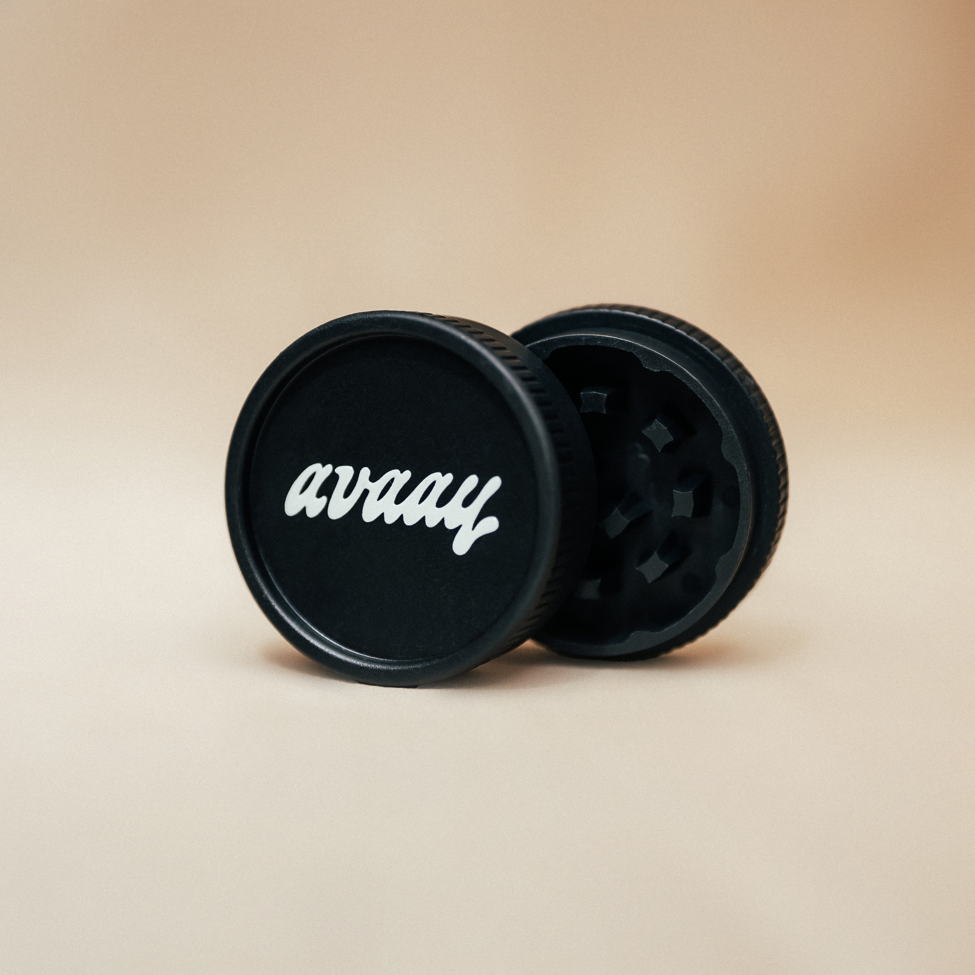 Schwarze, kompakte Kräutermühle mit weißem avaay Logo vor einem hellen Hintergrund.