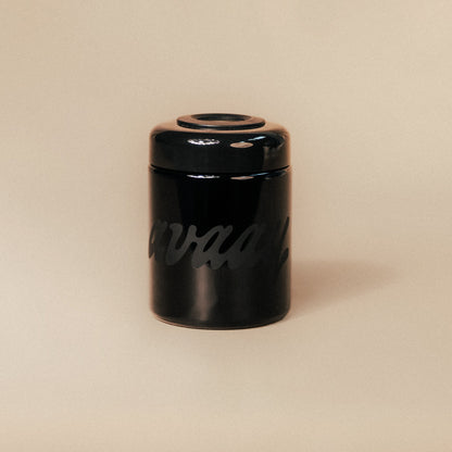 Verschlossener Violettglas Humidor aus der Cannasseur Club x avaay Kollaboration steht auf einem hellen Hintergrund.